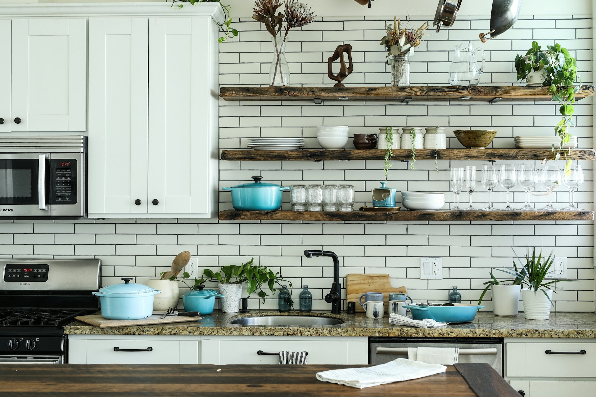 Cocina blanca con estantes abiertos de madera y utensilios a la vista